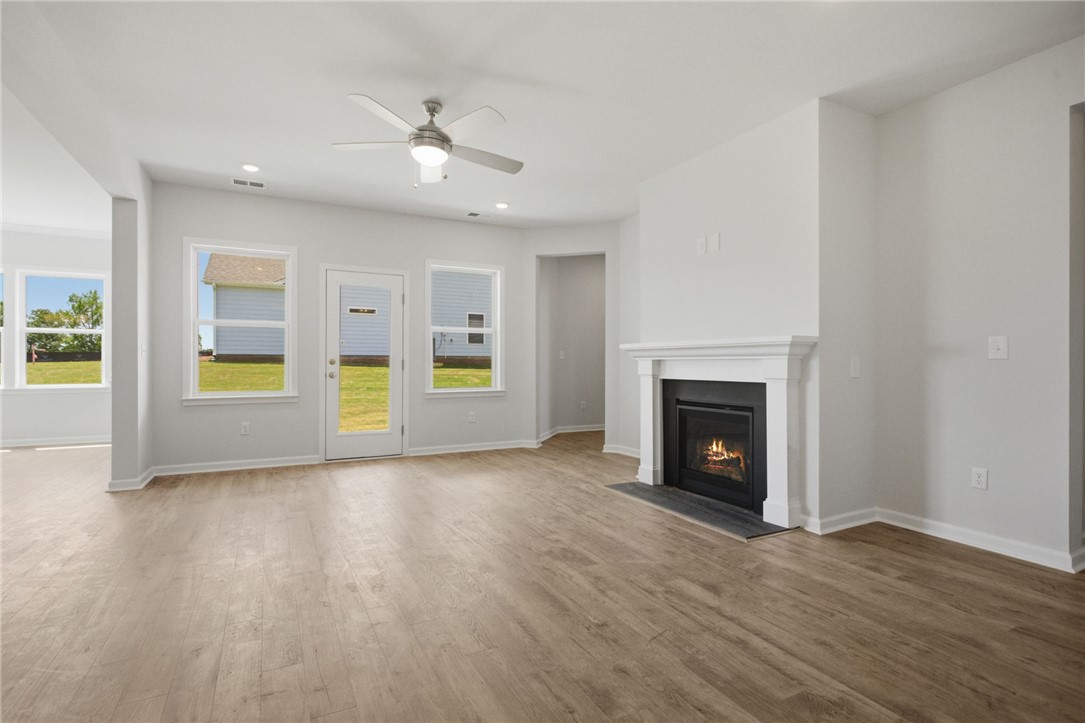 557 Hydrangea Street, Unit LOT 46 Seneca, SC 29678 - Photo 6 of 37 A well-lit living area features warm wood flooring and a classic fireplace.