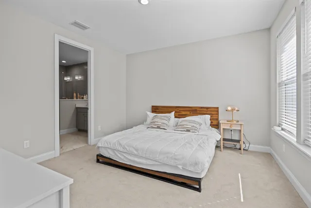 a bedroom with a bed and windows