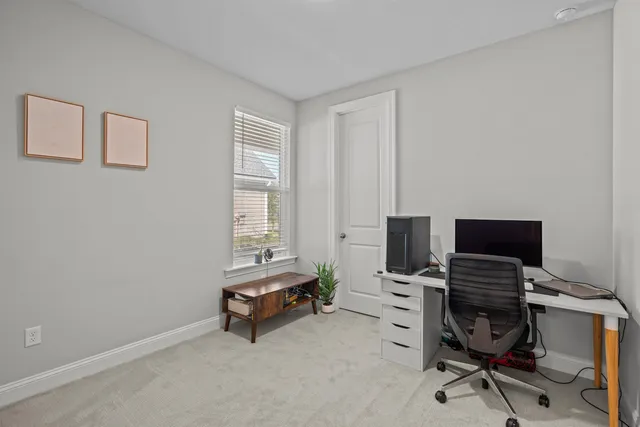 a view of a workspace with furniture and a window