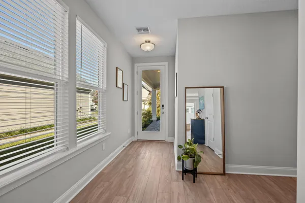 a view of a hallway with wooden floor and a chandelier