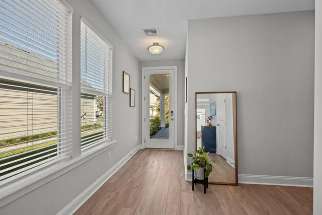 a view of a hallway with wooden floor and a chandelier