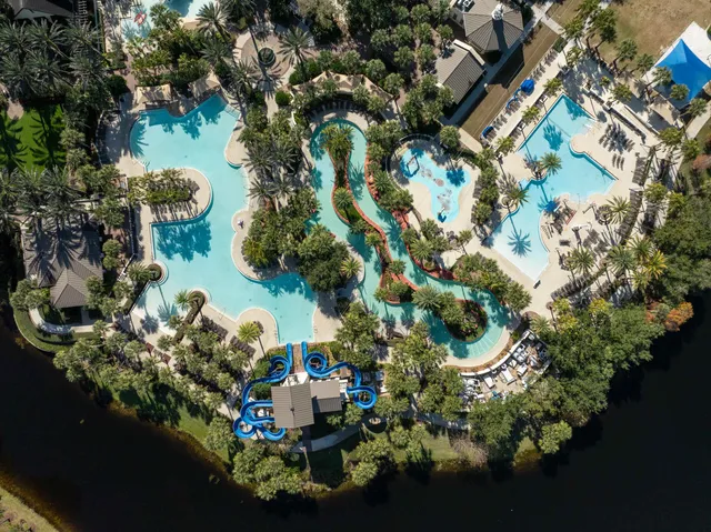 an aerial view of a house with a yard and lake view