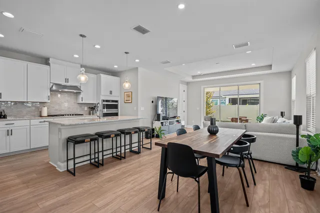 a kitchen with a dining table chairs and white appliances