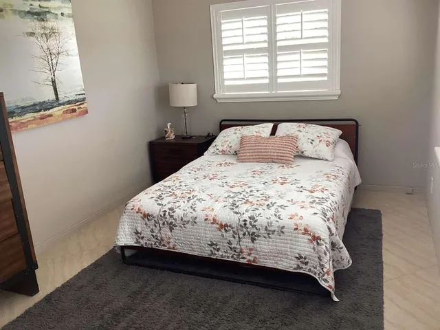 a bed sitting in a bedroom next to a window