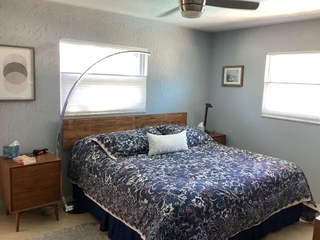 a bed sitting in a bedroom next to a window