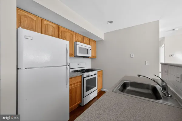 a kitchen with stainless steel appliances a refrigerator a sink a stove and cabinets
