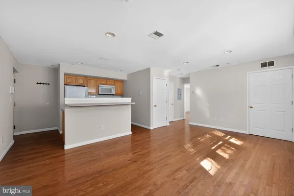 a view of a kitchen with wooden floor and a sink