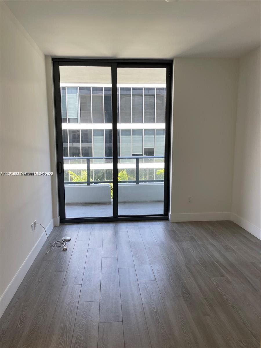 2960 Northeast 207th Street, Unit 1106 Aventura, FL 33180 - Photo 26 of 31 an empty room with wooden floor and windows