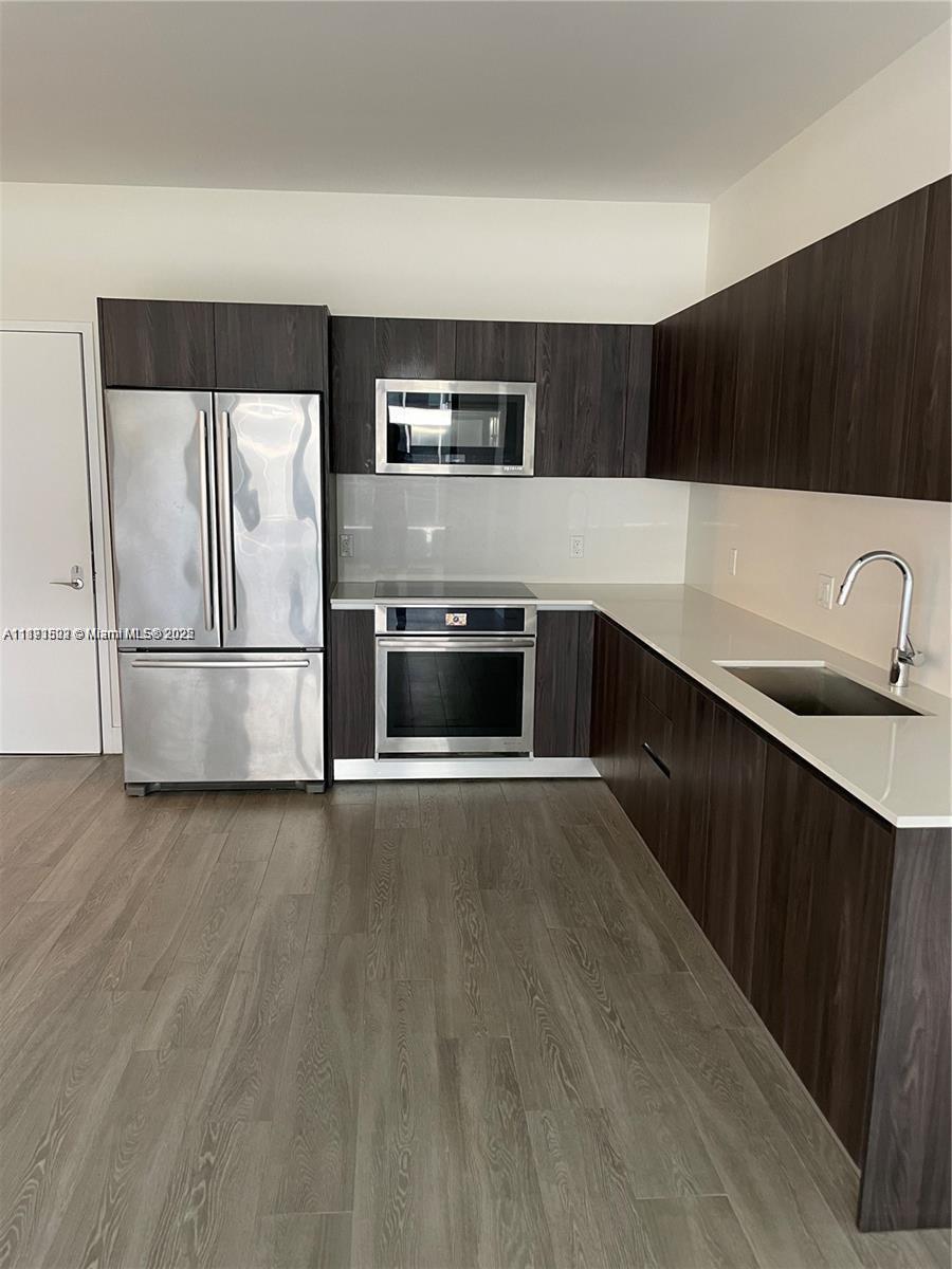 2960 Northeast 207th Street, Unit 1106 Aventura, FL 33180 - Photo 30 of 31 a kitchen with stainless steel appliances a refrigerator and a sink