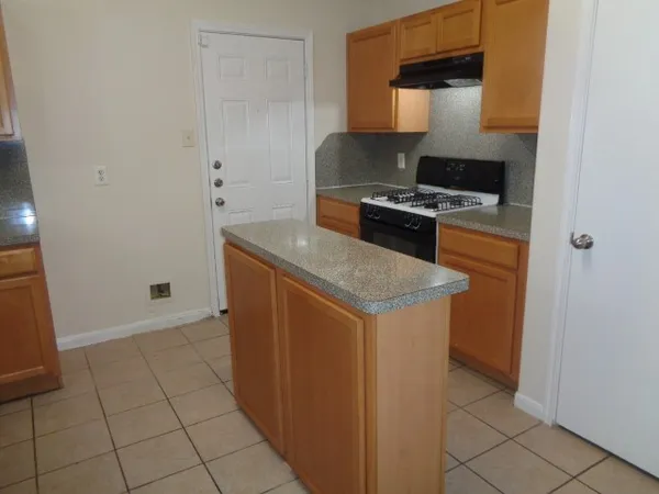 a kitchen with granite countertop a sink and a stove