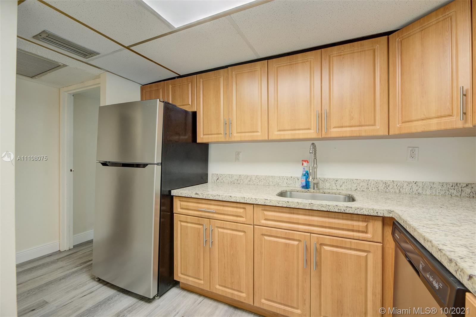 200 172nd Street, Unit 317 Sunny Isles Beach, FL 33160 - Photo 11 of 27 a kitchen with stainless steel appliances granite countertop a refrigerator and a sink