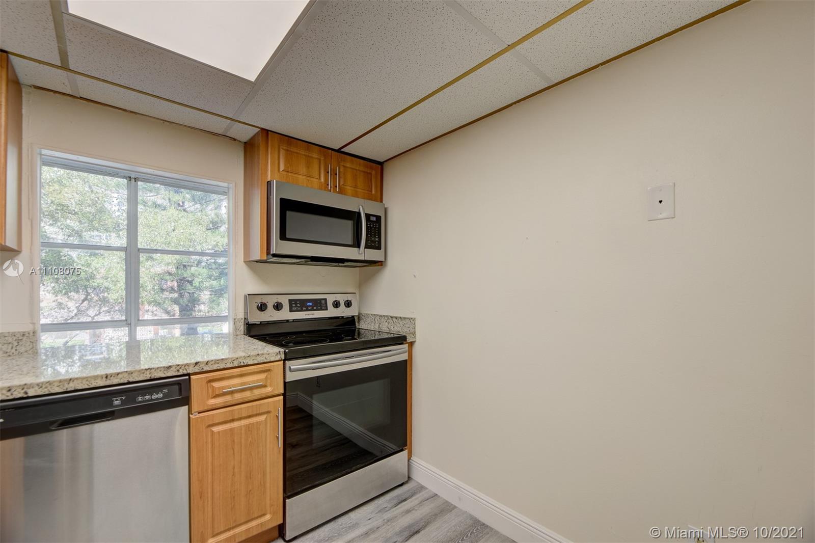 200 172nd Street, Unit 317 Sunny Isles Beach, FL 33160 - Photo 12 of 27 a kitchen with granite countertop cabinets stainless steel appliances and a window