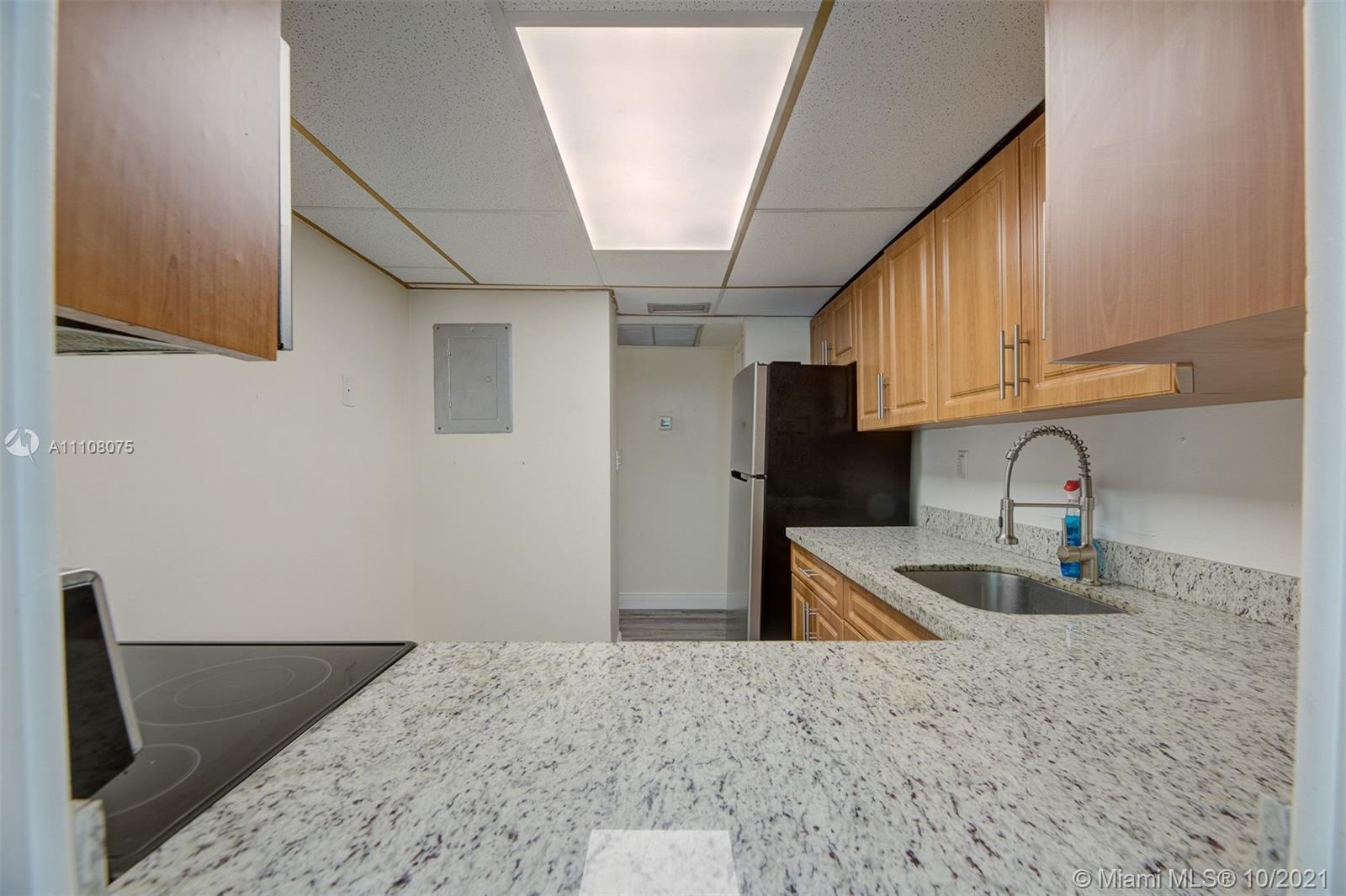 200 172nd Street, Unit 317 Sunny Isles Beach, FL 33160 - Photo 13 of 27 a kitchen with granite countertop a sink stove and refrigerator