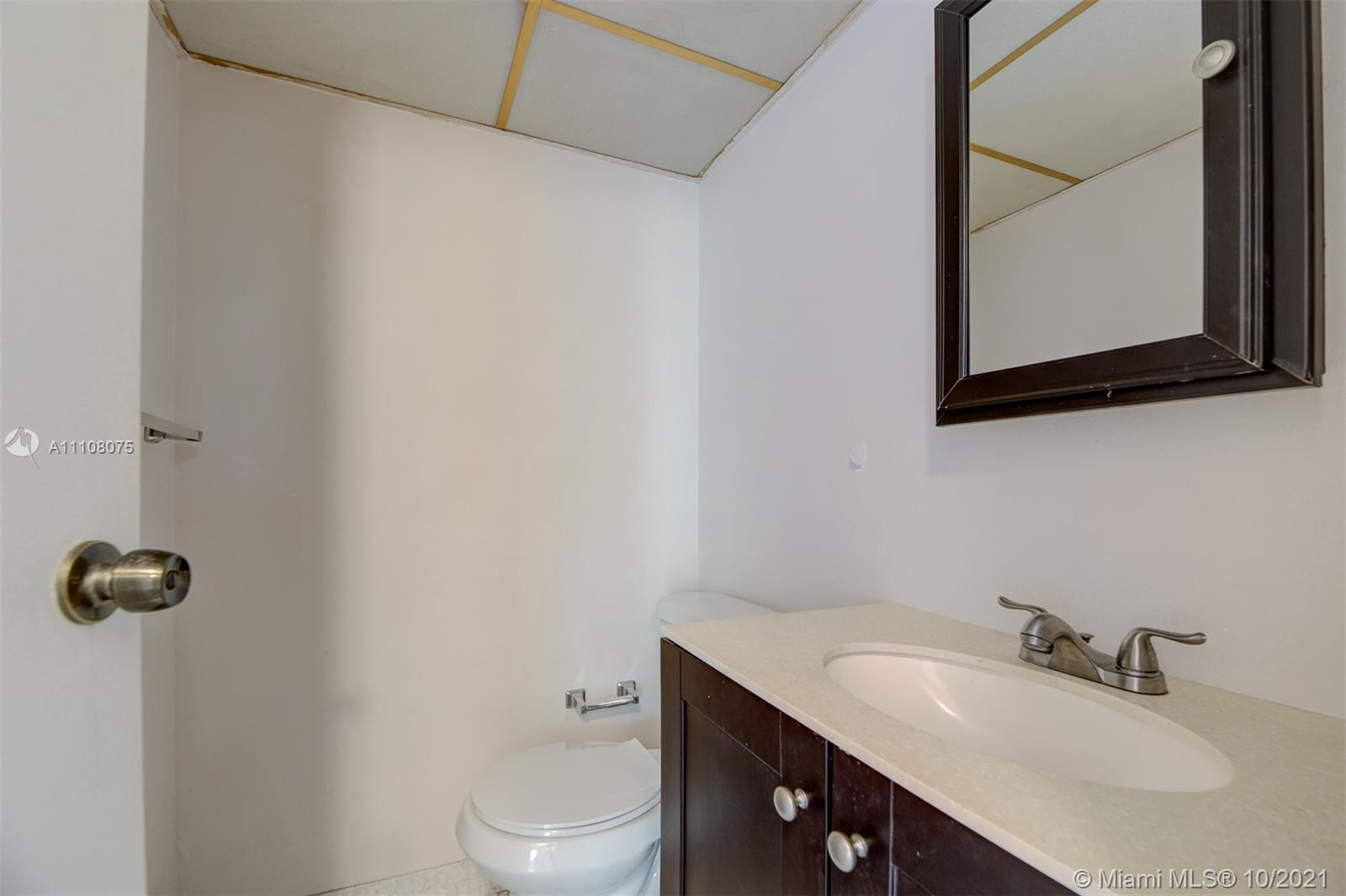 200 172nd Street, Unit 317 Sunny Isles Beach, FL 33160 - Photo 17 of 27 a bathroom with a granite countertop sink a toilet and mirror