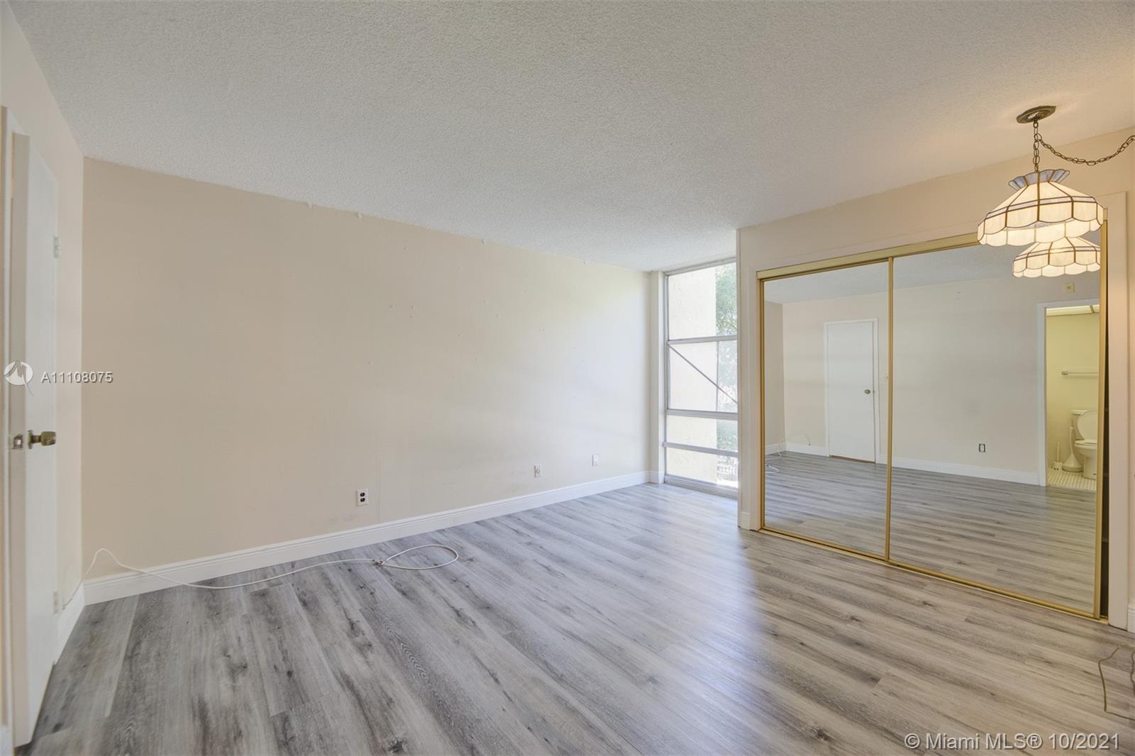 200 172nd Street, Unit 317 Sunny Isles Beach, FL 33160 - Photo 19 of 27 an empty room with wooden floor and windows
