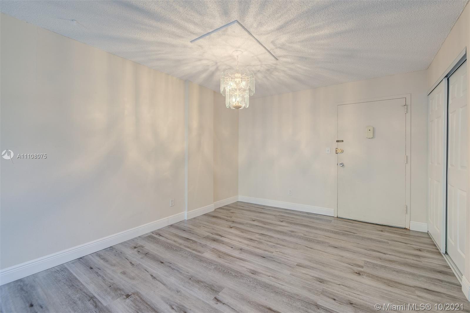200 172nd Street, Unit 317 Sunny Isles Beach, FL 33160 - Photo 3 of 27 a view of an empty room with wooden floor and window