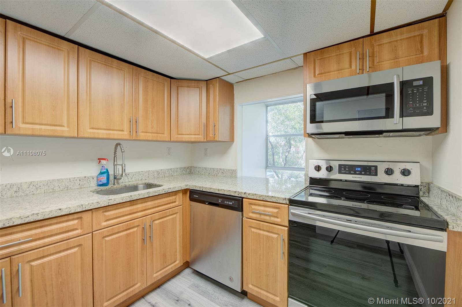 200 172nd Street, Unit 317 Sunny Isles Beach, FL 33160 - Photo 10 of 27 a kitchen with stainless steel appliances granite countertop a stove microwave and sink