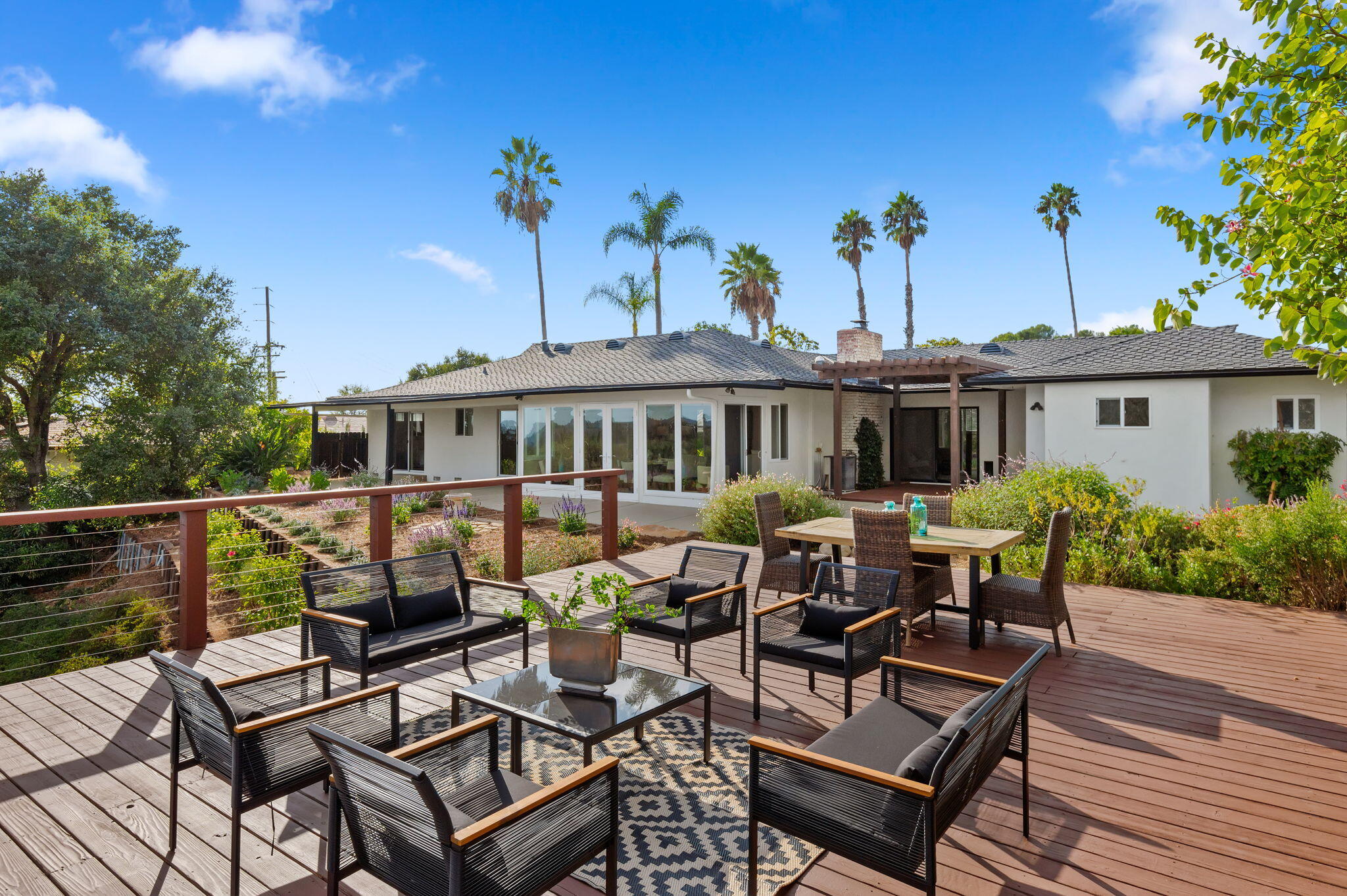 a view of a patio with couches table and chairs and potted plants