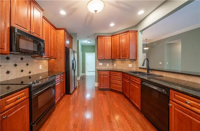 a kitchen with stainless steel appliances wooden cabinets counter space a sink and a stove