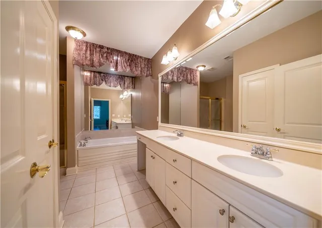 a spacious bathroom with a sink double vanity granite and a mirror