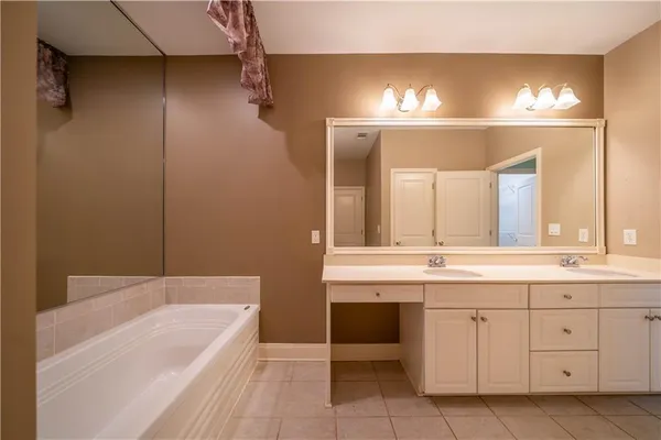 a bathroom with a tub a sink and mirror