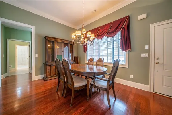 a dining room with furniture wooden floor and a chandelier