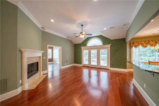 a view of an empty room with window wooden floor and fire place