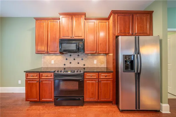 a kitchen with granite countertop a refrigerator stove and microwave