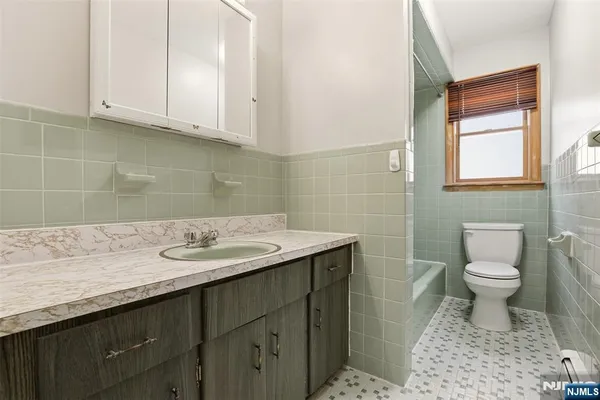 a bathroom with a sink a toilet and a window