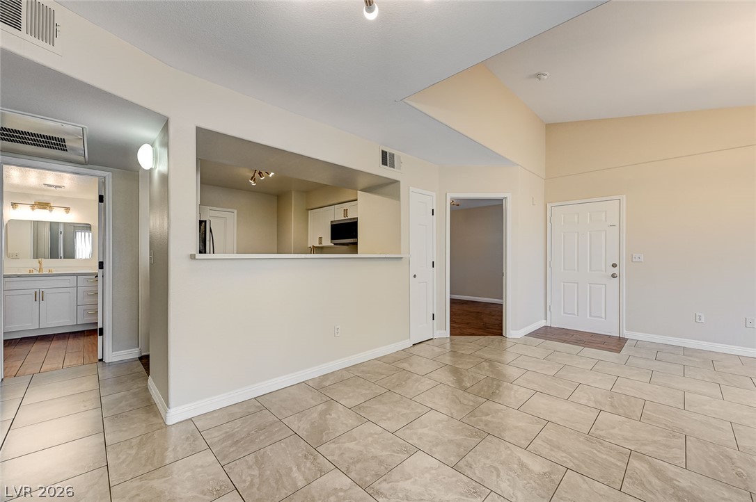 7255 West Sunset Road, Unit 2005 Las Vegas, NV 89113 - Photo 14 of 27 A versatile open-concept living area with tile flooring seamlessly connects to the kitchen and an adjacent bathroom.