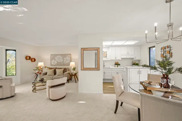 a living room with furniture a dining table and chairs with kitchen view