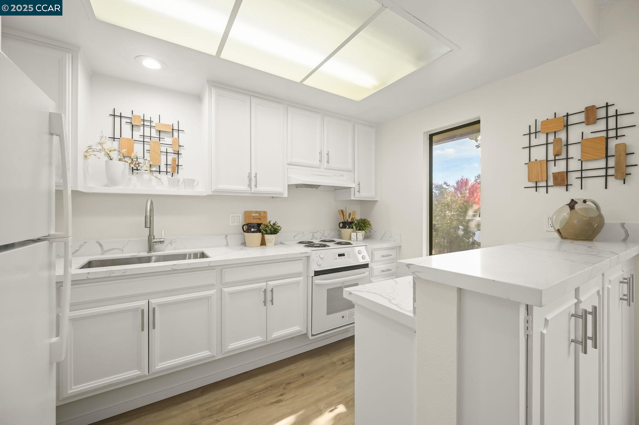 1324 Singingwood Court, Unit 3 Walnut Creek, CA 94595 - Photo 8 of 36 a kitchen with a sink cabinets and wooden floor