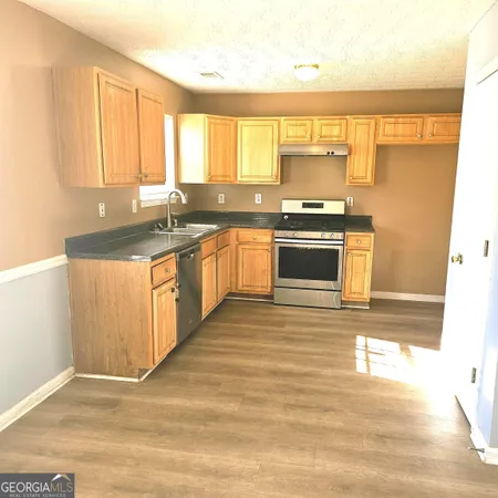 a kitchen with stainless steel appliances granite countertop a stove a sink and a microwave