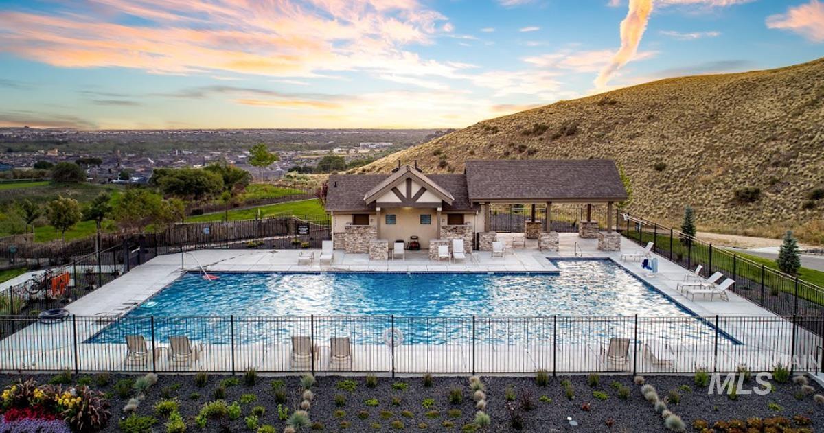 6169 East Prominence Court Boise, ID 83716 - Photo 38 of 43 Pool at dusk featuring a patio and a community pool