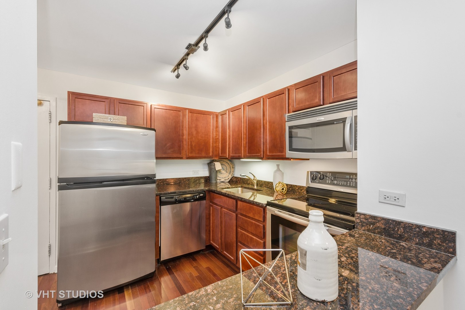 222 East Pearson Street, Unit 707 Chicago, IL 60611 - Photo 6 of 13 a kitchen with a refrigerator a stove a sink dishwasher and wooden cabinets with wooden floor