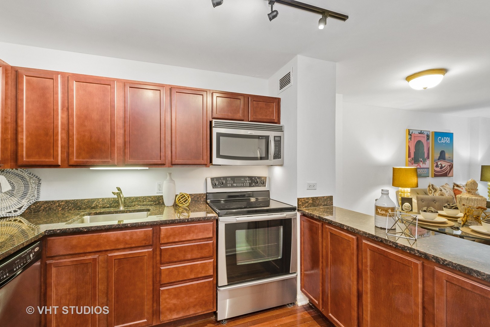 222 East Pearson Street, Unit 707 Chicago, IL 60611 - Photo 7 of 13 a kitchen with granite countertop stainless steel appliances and wooden cabinets