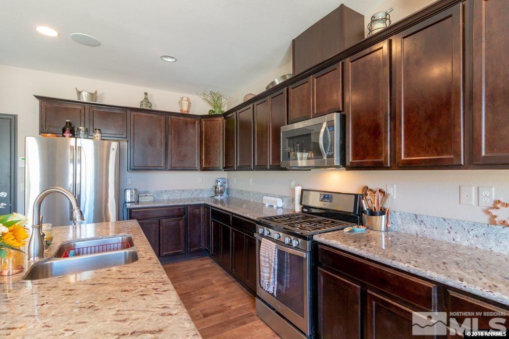 9635 Caitlin Court Reno, NV 89521 - Photo 8 of 23 a kitchen with granite countertop a sink stainless steel appliances and cabinets