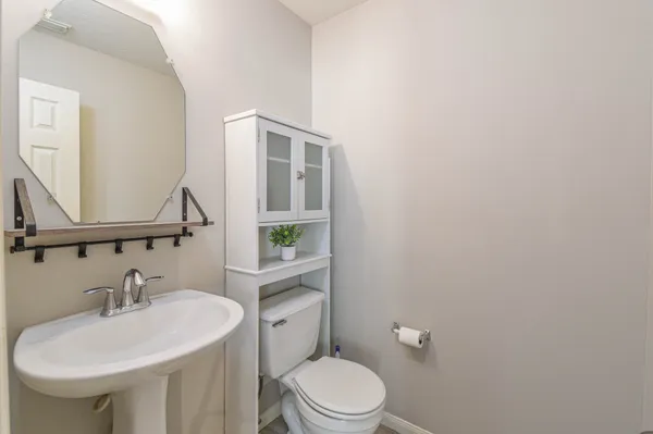 a bathroom with a sink a toilet and mirror