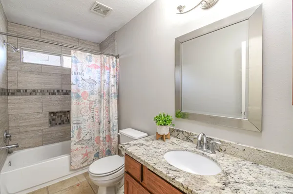 a bathroom with a granite countertop sink toilet and shower