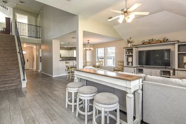 a dining hall with stainless steel appliances kitchen island granite countertop a table chairs and a view of kitchen