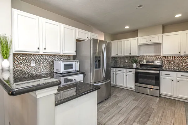a dining room with wooden floor a chandelier a wooden table and chairs