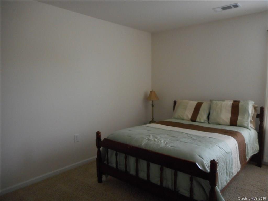 2987 Arthur Road, Unit 173 Indian Land, SC 29707 - Photo 14 of 18 a bed sitting in a bedroom next to a window