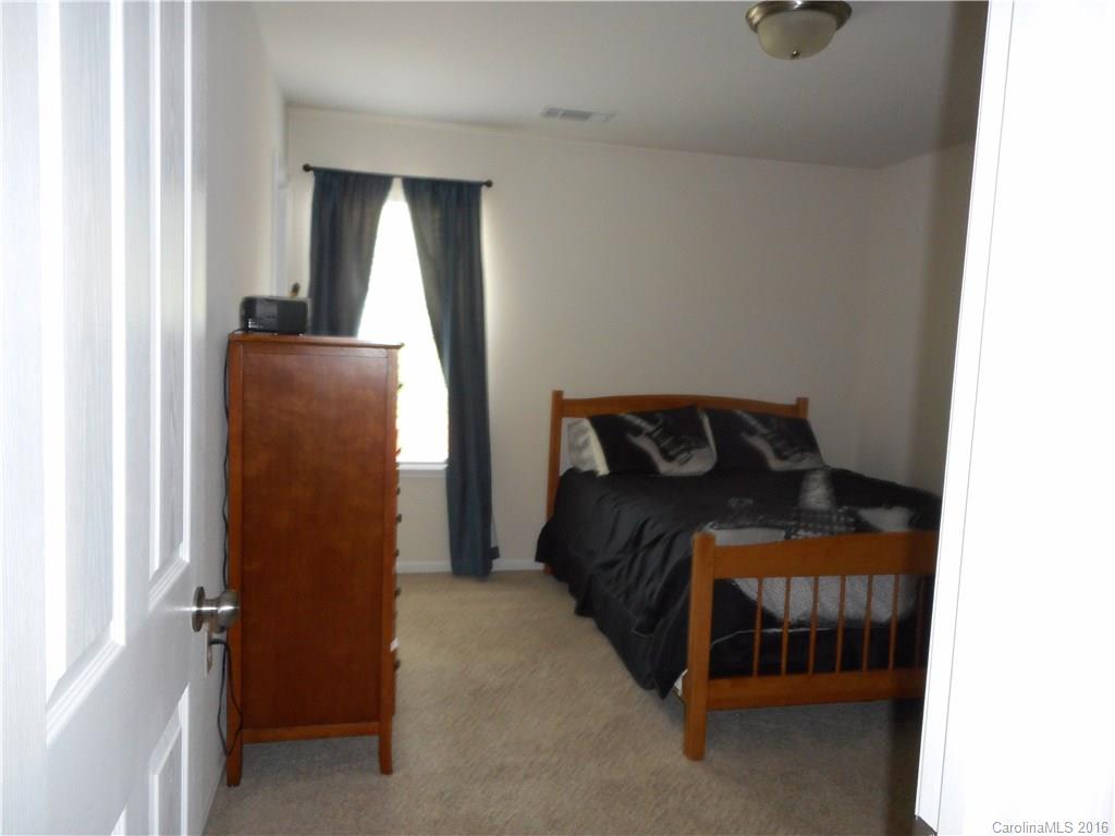 2987 Arthur Road, Unit 173 Indian Land, SC 29707 - Photo 16 of 18 a bedroom with a bed and a mirror