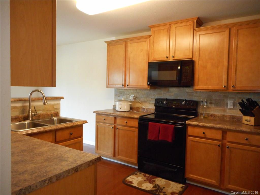 2987 Arthur Road, Unit 173 Indian Land, SC 29707 - Photo 18 of 18 a kitchen with stainless steel appliances granite countertop a stove a sink and a microwave