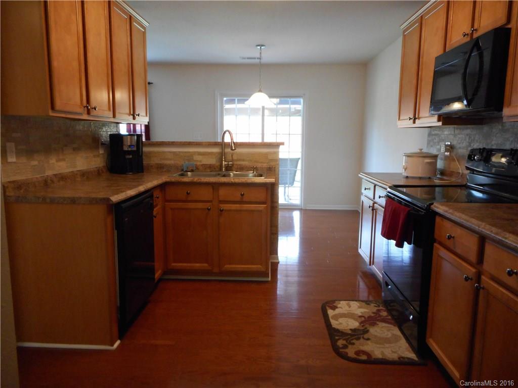 2987 Arthur Road, Unit 173 Indian Land, SC 29707 - Photo 5 of 18 a kitchen with stainless steel appliances granite countertop a stove a sink and a microwave