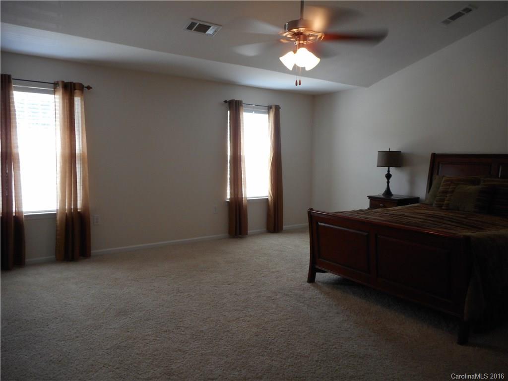 2987 Arthur Road, Unit 173 Indian Land, SC 29707 - Photo 10 of 18 a bed room with a bed and a chandelier