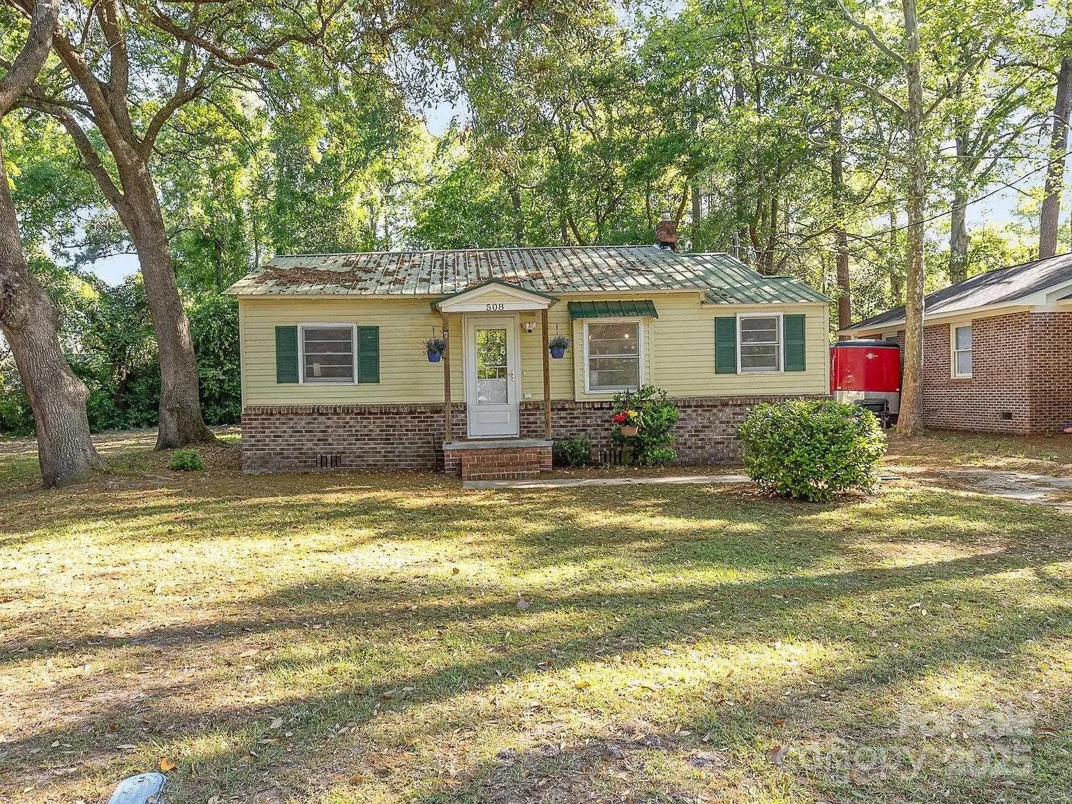 a front view of house with yard and trees around