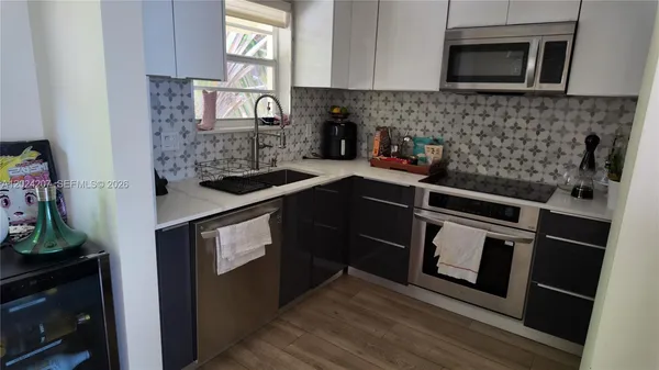 a kitchen with stainless steel appliances granite countertop a stove a microwave and a sink