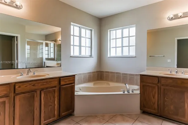 a bathroom with a tub sink and mirror