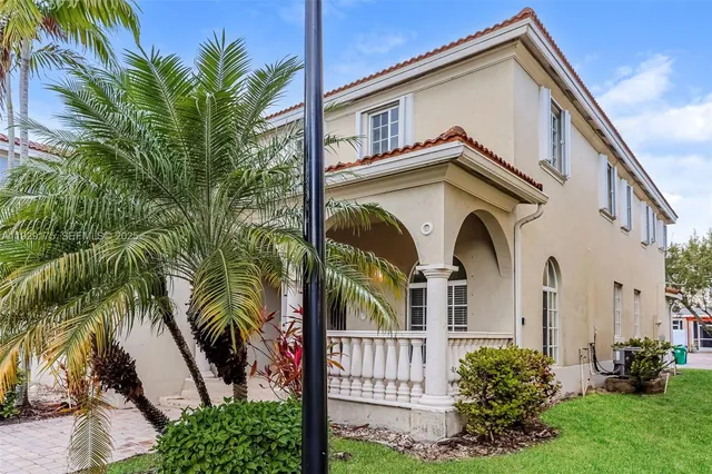 a view of a house with a small yard plants and palm trees
